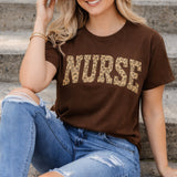 Woman wearing a brown 'NURSE' t-shirt sitting on steps.